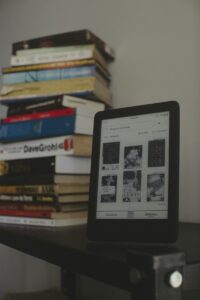 a tablet sitting on top of a table next to a pile of books